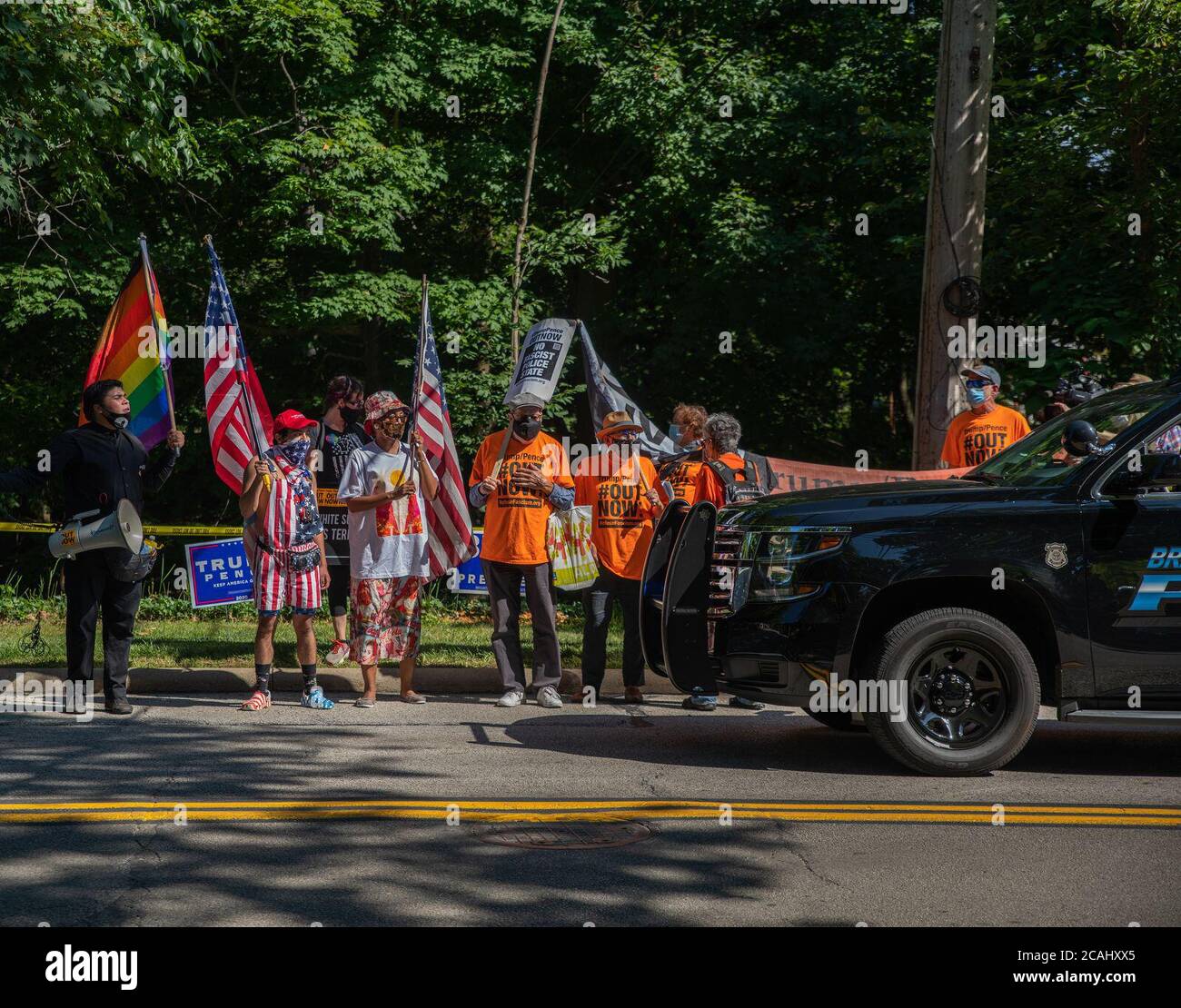 Bratenahl, USA. 06th Aug, 2020. Anti-President Trump protestors stand in the road, blocking a police car, in front of the Shoreby Club in Bratenahl, Ohio on August 6, 2020. President Trump plans to attend a private fundraiser at the Shoreby Club later in the evening. (Photo by Matt Shiffler/Sipa USA) Credit: Sipa USA/Alamy Live News Stock Photo