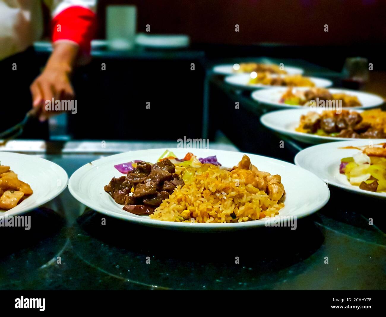 Chef dishing up plates with beef stir fry with egg fried rice Stock Photo Alamy