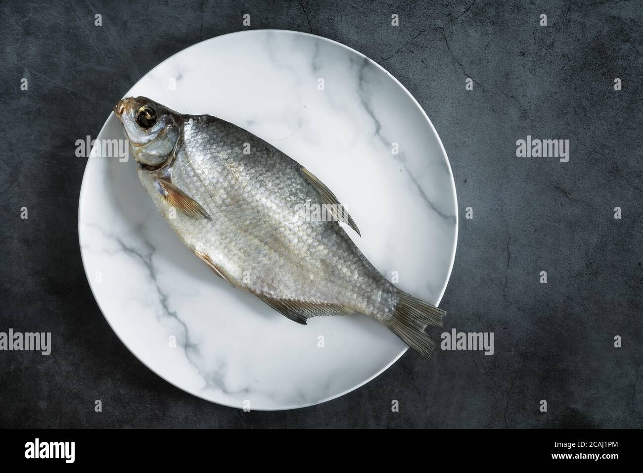 Salted and dried fish on a plate Stock Photo