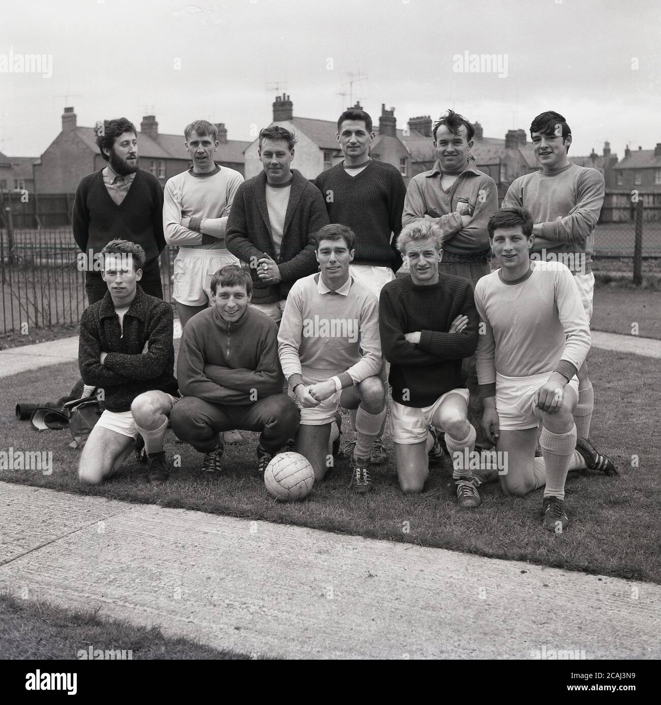 1965, historical, amateur village football team, group picture, showing the soccer kit, boots and sports clothing of the day, Bucks, England, UK. Eleven men are in the photo, but not sure why only 10 footballers are in kit or tracksuits.... Stock Photo