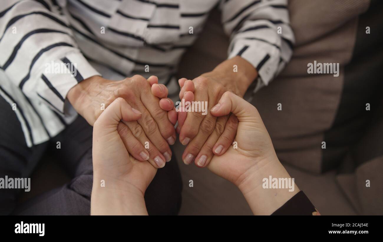 Empathy and compassion for elderly. Young woman holding hands of a senior lady. High quality 4k footage Stock Photo