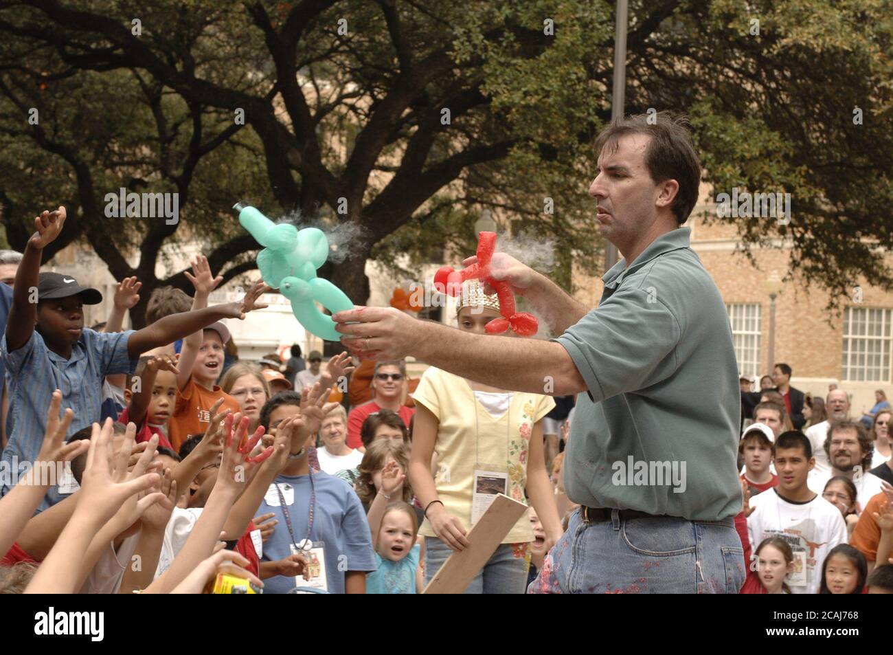 Austin, Texas USA, March 4, 2006: Children watch a 'Chemistry Circus' put on by professor Dr. David Laude as part of an open house 'Explore UT' at the University of Texas at Austin.  Dr. Laude shrinks air-filled balloons by dipping them in liquid nitrogen.  ©Bob Daemmrich Stock Photo