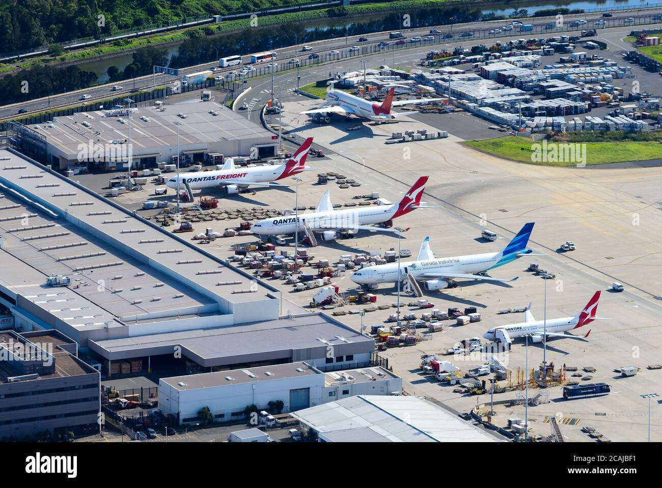 Cargo ramp at Sydney International Airport in Australia. Qantas Airways aircraft at remote stand with multiple cargo pallets around. Freighters area. Stock Photo
