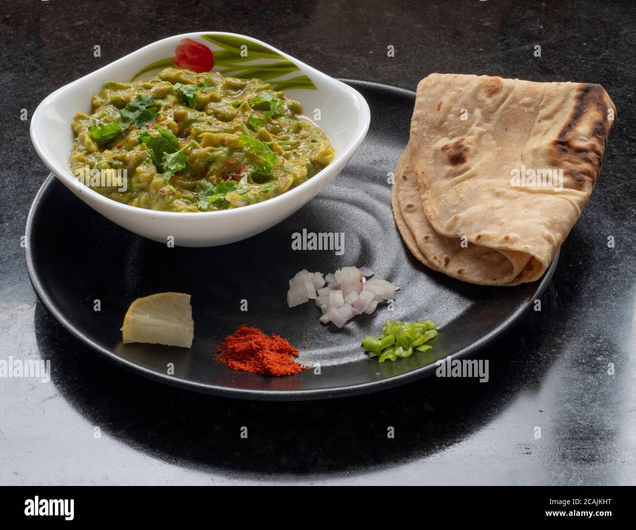 Guacamole in a bowl served with chapati and toppings Stock Photo