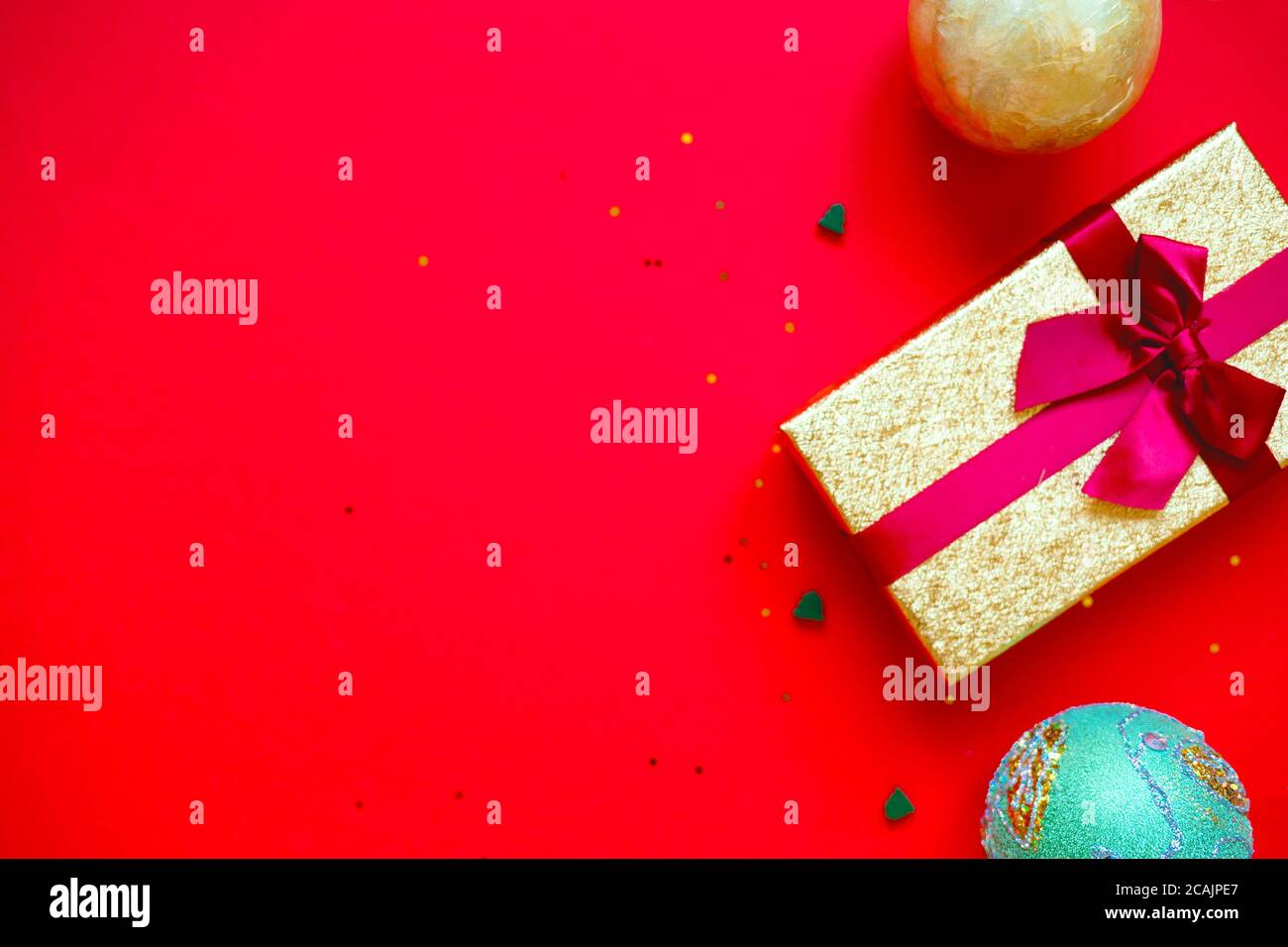 gift boxes with bows and Christmas toys on a red-gold background Stock ...