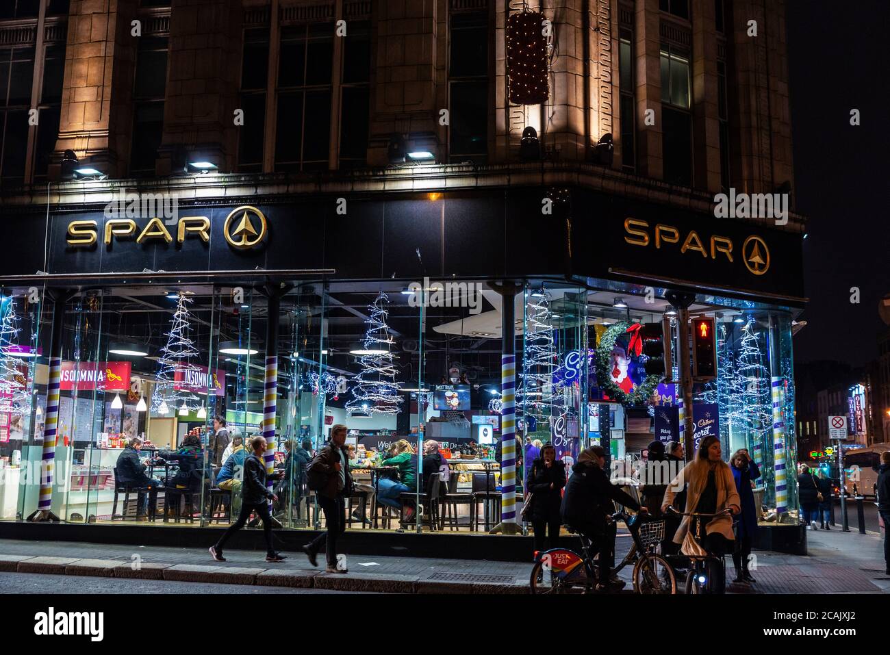 Dublin, Ireland - December 30, 2019: Shopping street at night with a Spar supermarket with christmas decoration and people around in the center of Dub Stock Photo