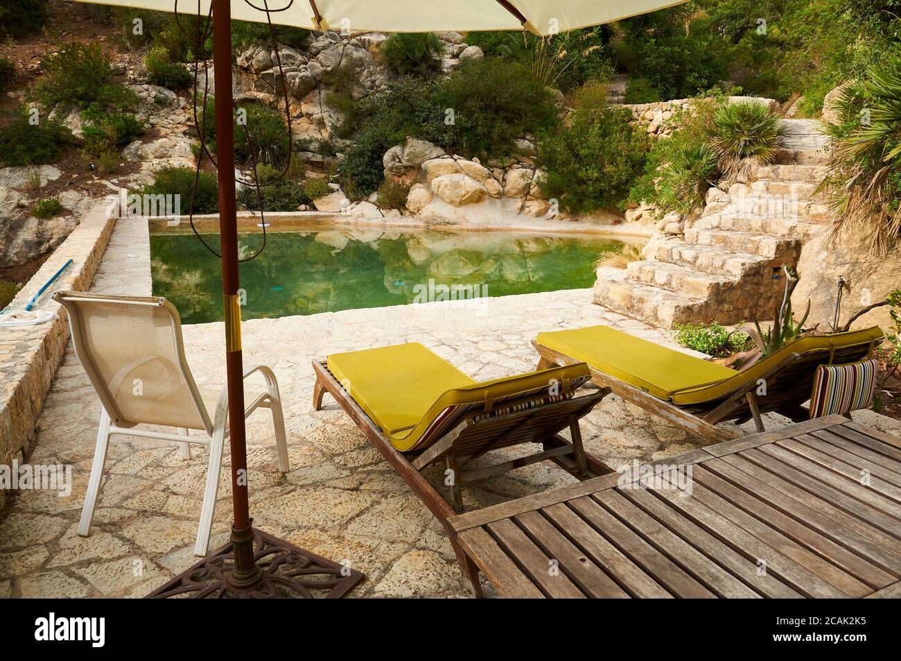 Hammocks in a natural water outdoor swimming pool surrounded by nature at a property in Serra de Tramuntana (Andratx, Majorca, Balearic Islands,Spain) Stock Photo