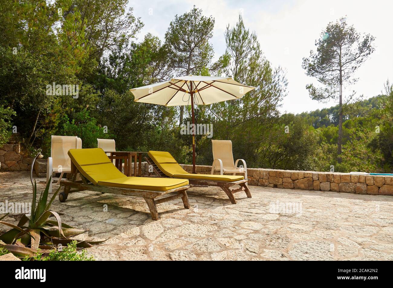 Hammocks and sun umbrella surrounded by nature at a property in Serra de Tramuntana mountain range (Andratx, Majorca, Balearic Islands, Spain) Stock Photo