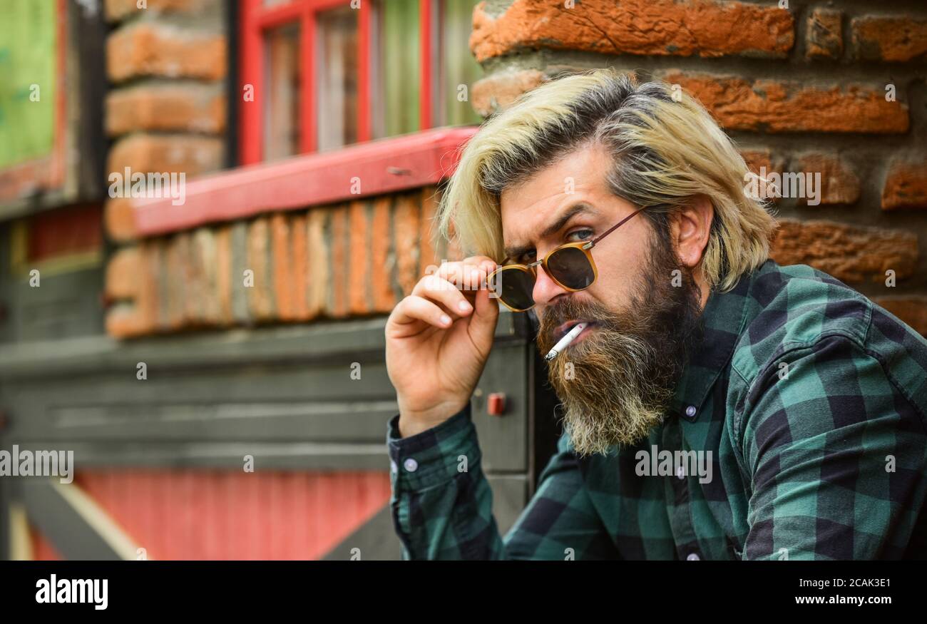 Mental health. Hipster smoking old architecture background. Medical  cannabis. Guy in sunglasses smoking tobacco. Smoking outdoors. Smoking  habit. Man with cigarette. Cool guy relaxing. Reduce stress Stock Photo