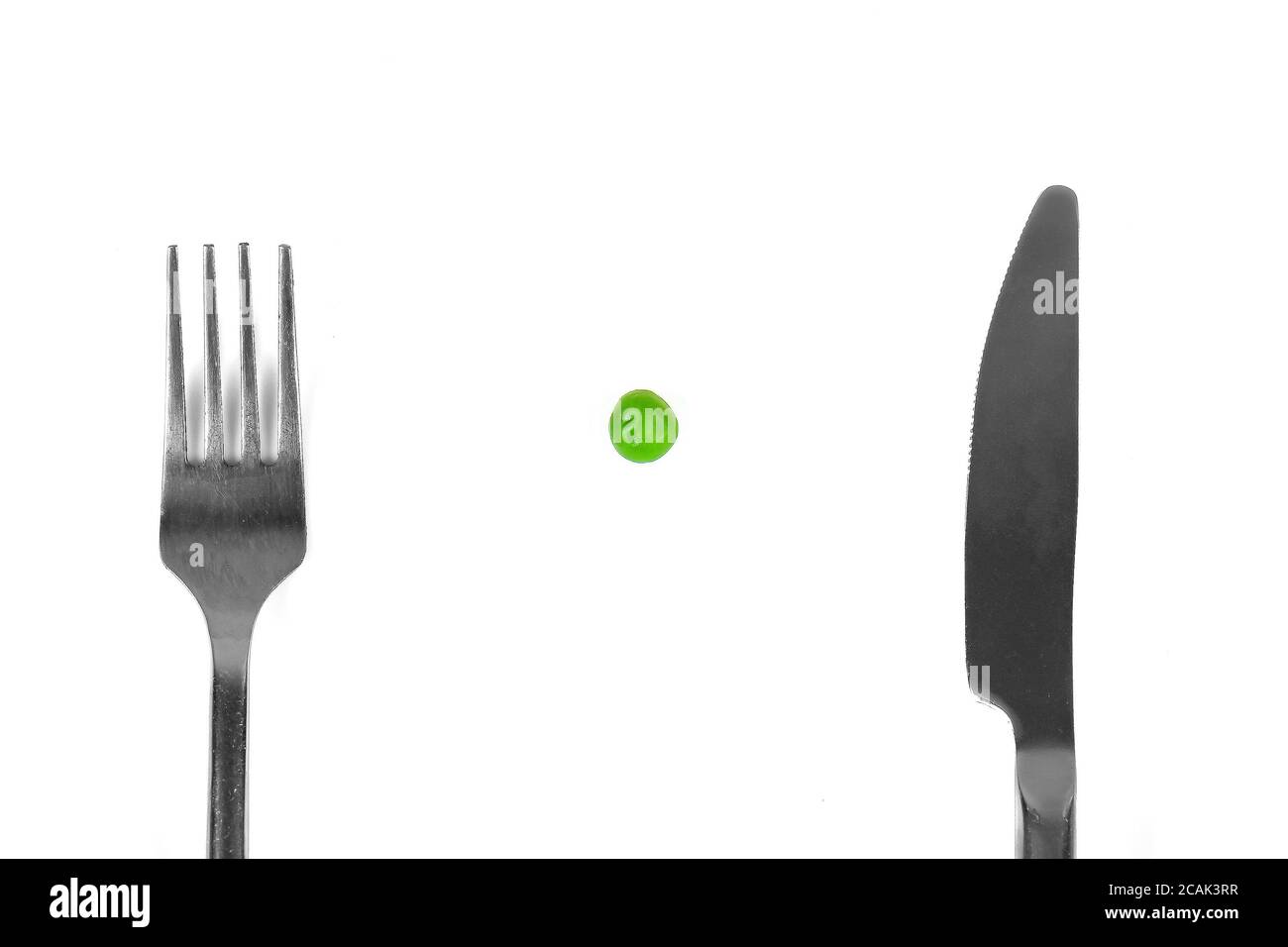 Small meal of one pea and silver cutlery as eating disorder concept