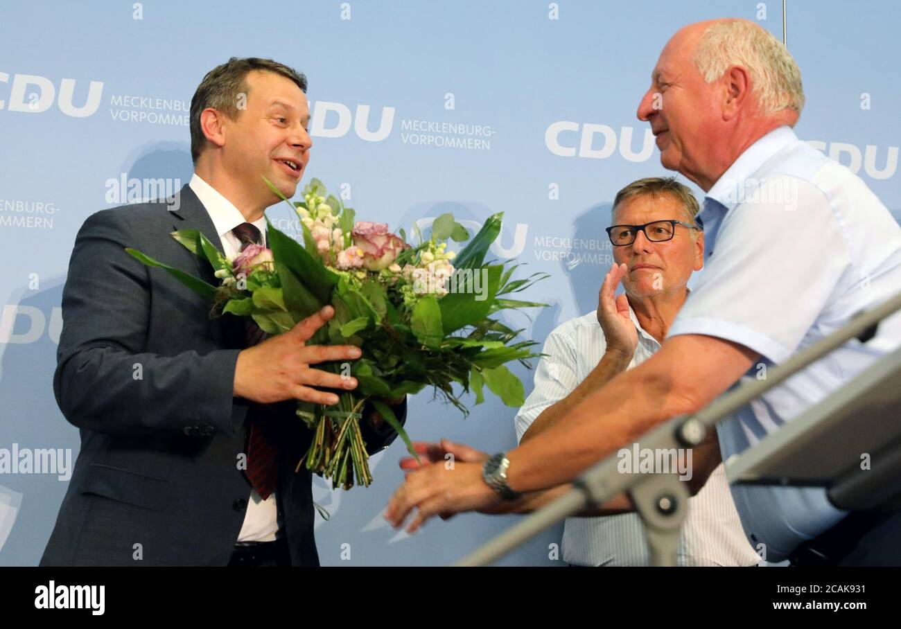 07 August 2020, Mecklenburg-Western Pomerania, Güstrow: After his election as the new state chairman of the CDU with 94.8 percent of the votes, Michael Sack (l-r), district administrator, receives a bouquet of flowers from Klaus-Dieter Götz, state managing director, and Eckhardt Rehberg, member of the Bundestag. Photo: Bernd Wüstneck/dpa-Zentralbild/dpa Stock Photo