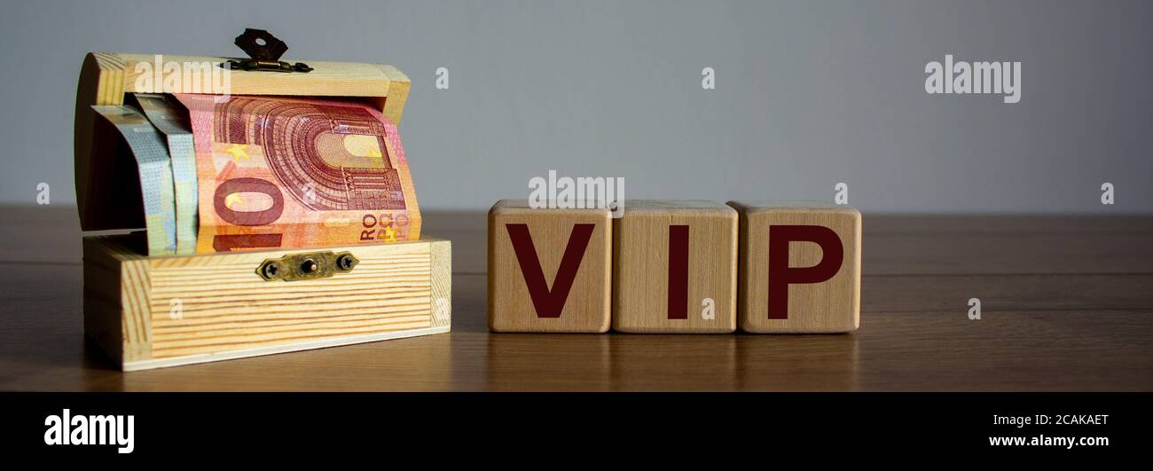 Concept word vip on cubes on a beautiful wooden table, small chest with ...