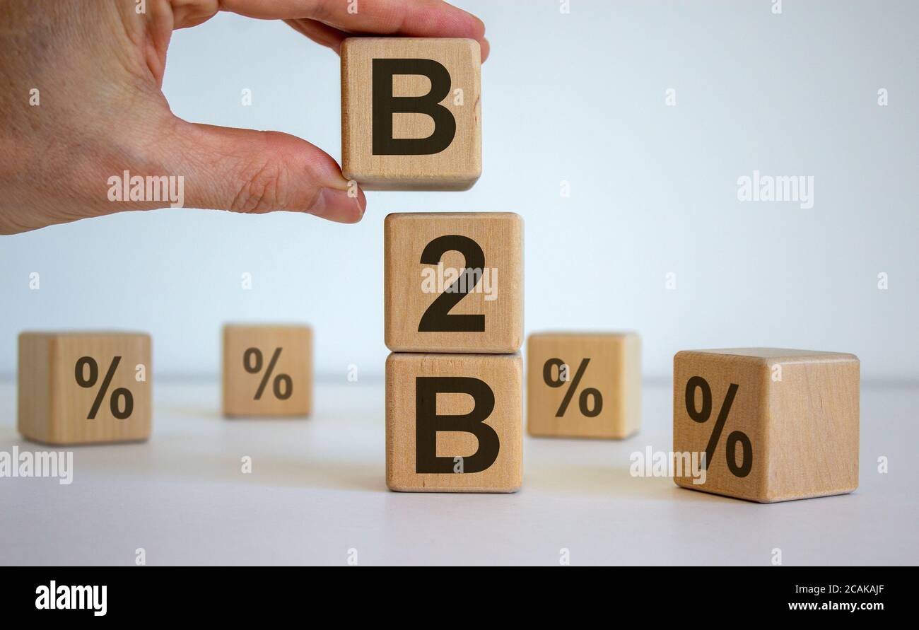 Male hand placing a cube with letter B on top of a other cubes. B2B text. Beautiful white background. Stock Photo