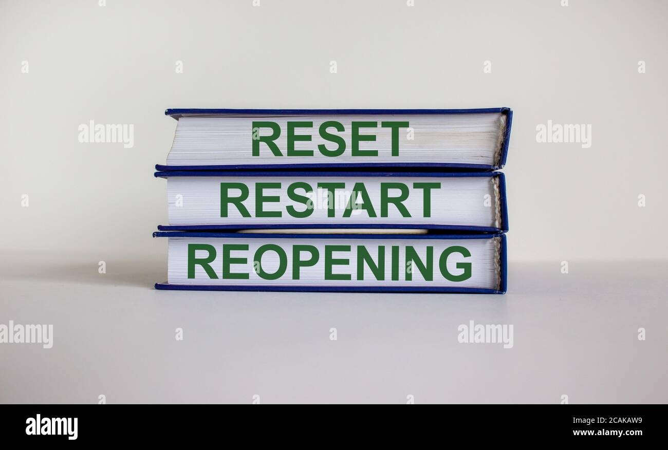 Books with text 'reset, restart, reopening' on beautiful white background. Business concept. Copy space. Stock Photo