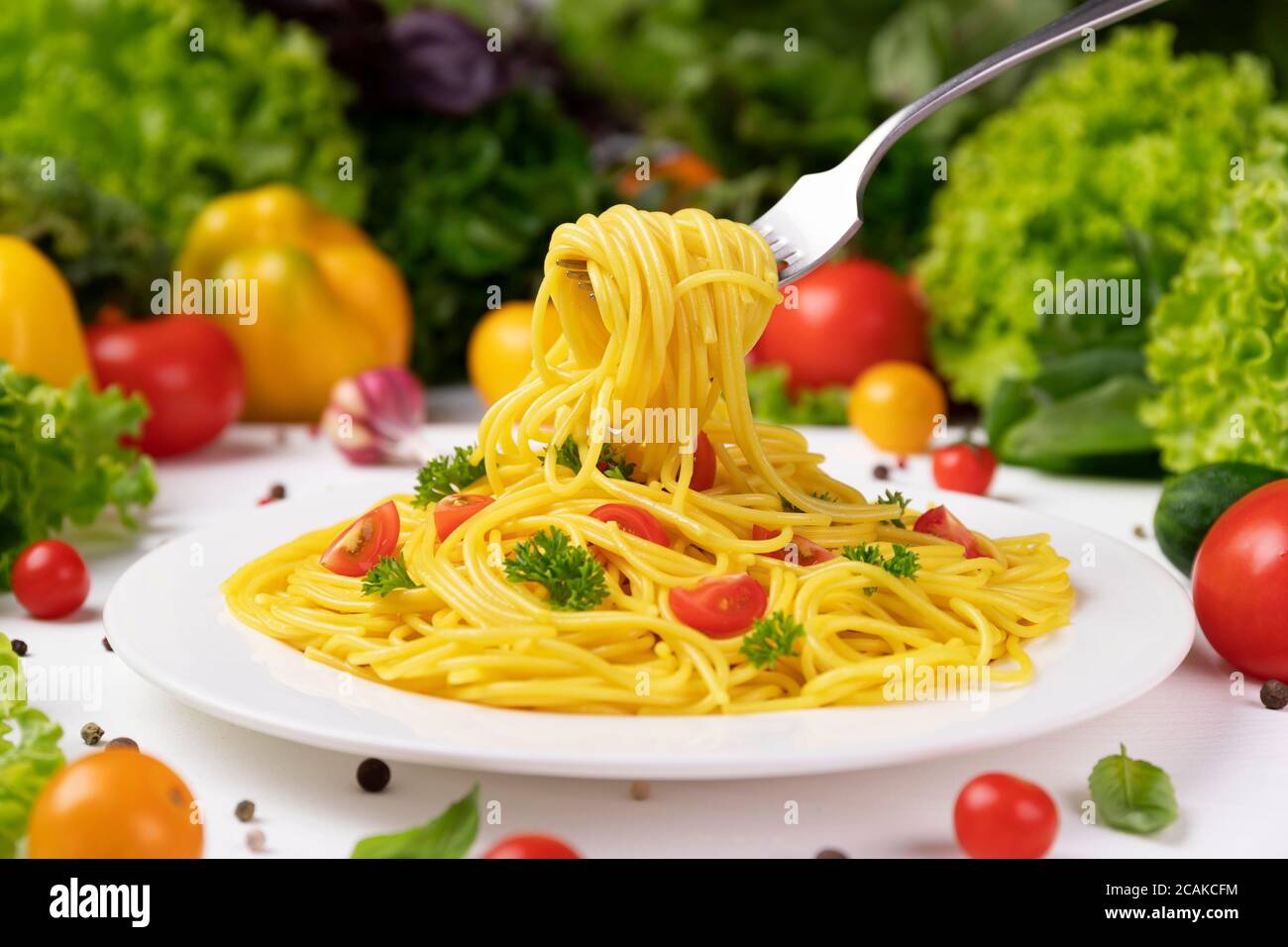 Plate of italian pasta, spaghetti on fork with tomatoes and basil Stock Photo