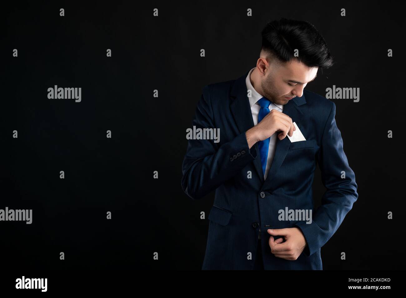 Portrait of business man wearing blue business suit and tie take out ...