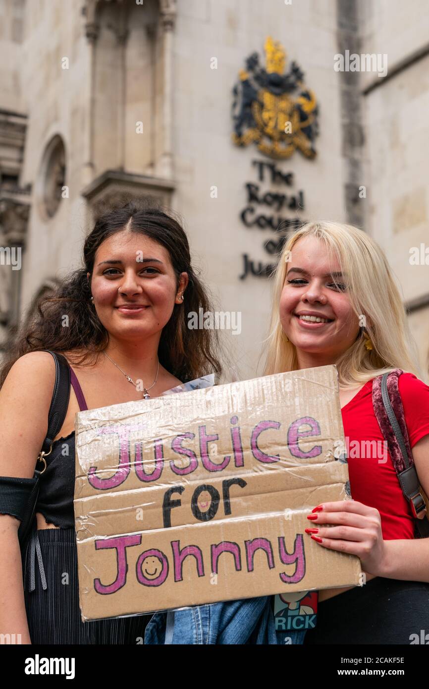 LONDON, ENGLAND - JULY 28, 2020: Beautiful female supporters holding a banner for Johnny Depp fan outside the High Court in London during his Court ca Stock Photo