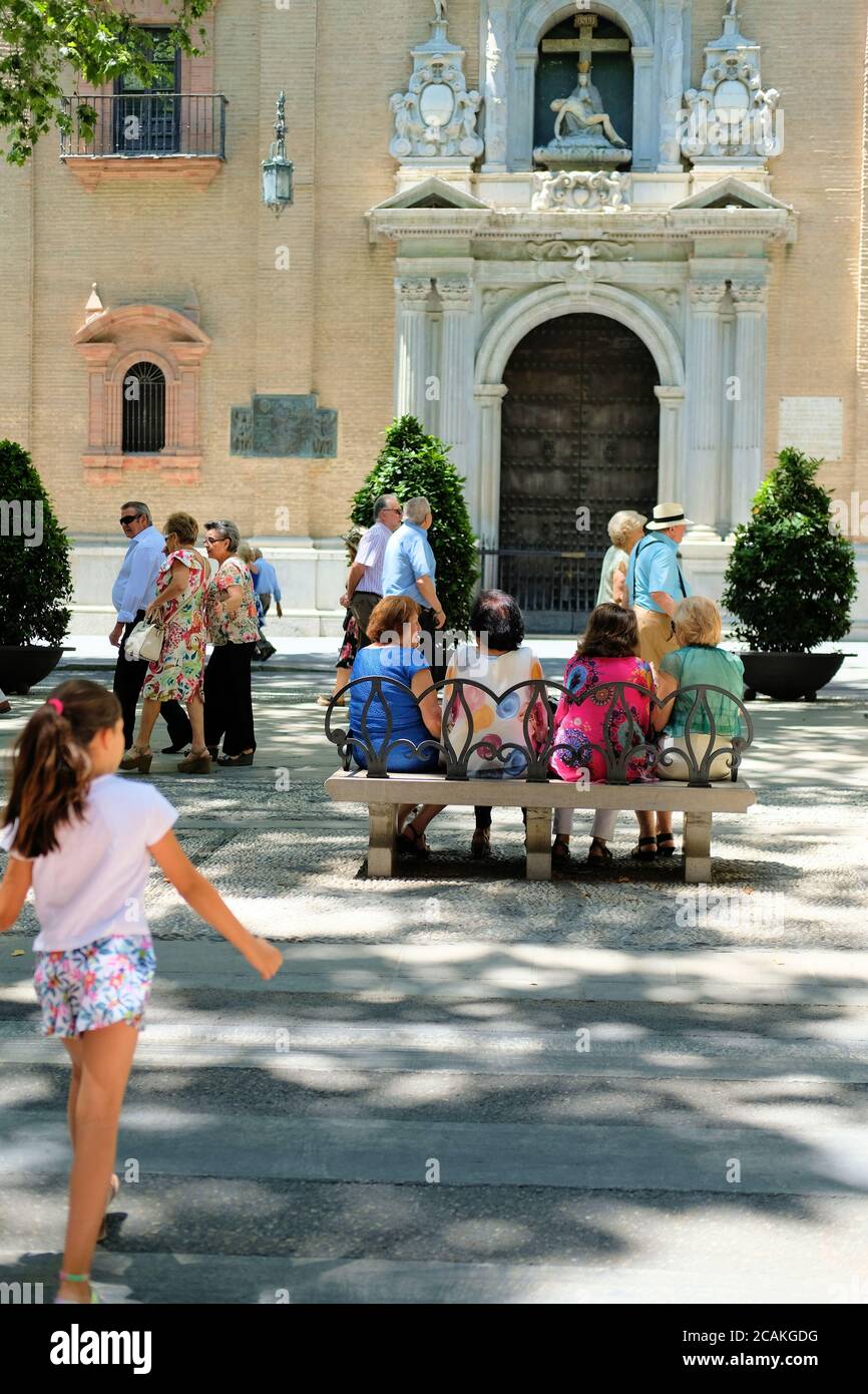 Local Spaniards out for a Sunday stroll in Granada, Spain's Plaza de  Bibataubin; women sitting on a park bench across from the Church of  Angustias Stock Photo - Alamy