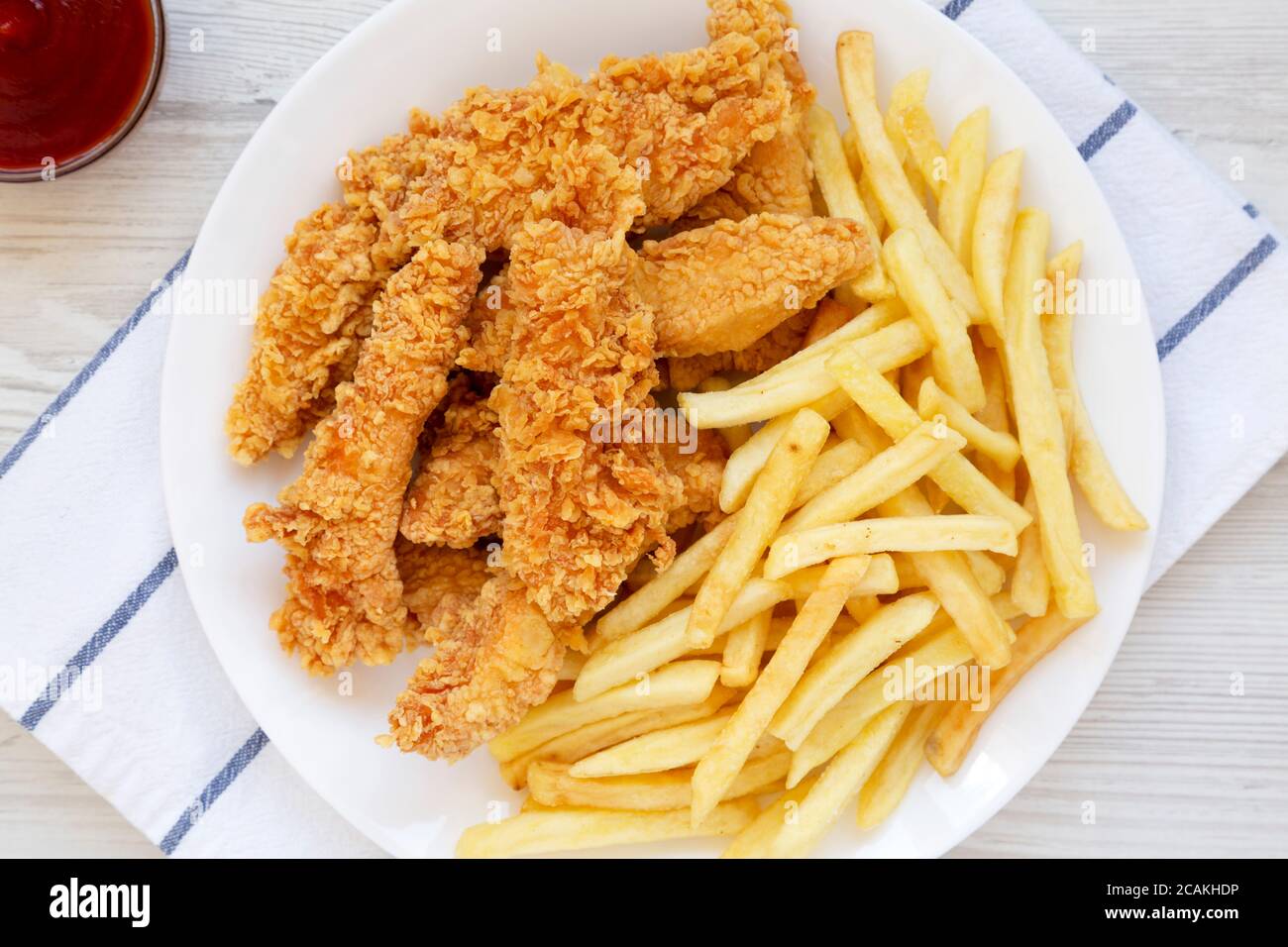 Homemade Crispy Chicken Tenders and French Fries on a white plate, top