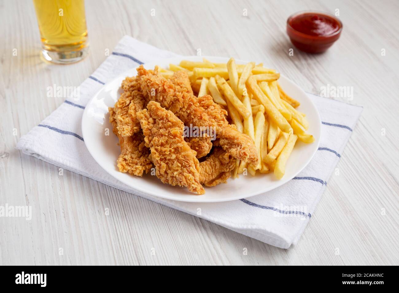 Homemade Crispy Chicken Tenders and French Fries with sauce and glass