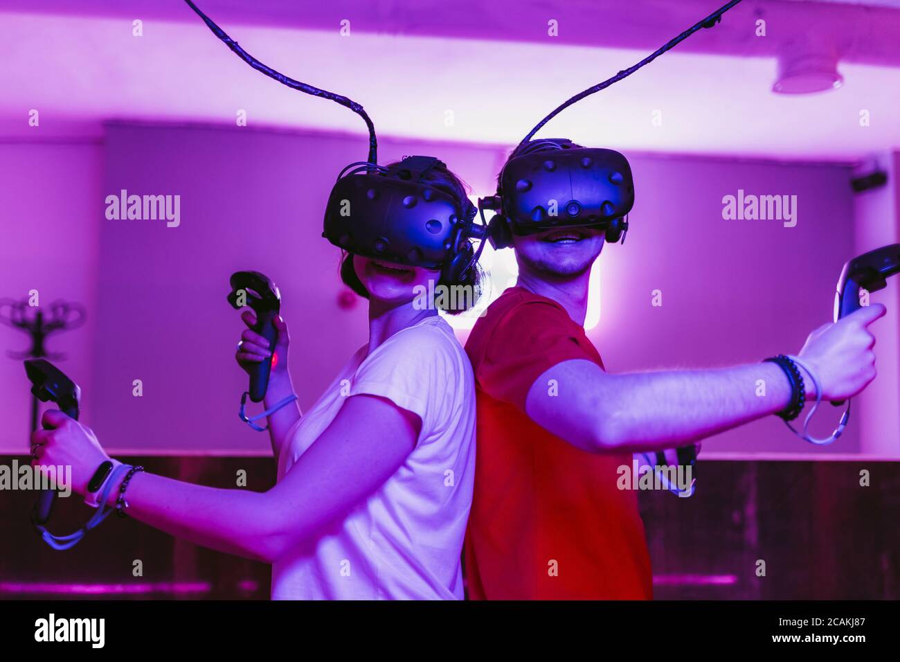 The guy and the girl play virtual reality games. Neon game room Stock Photo  - Alamy