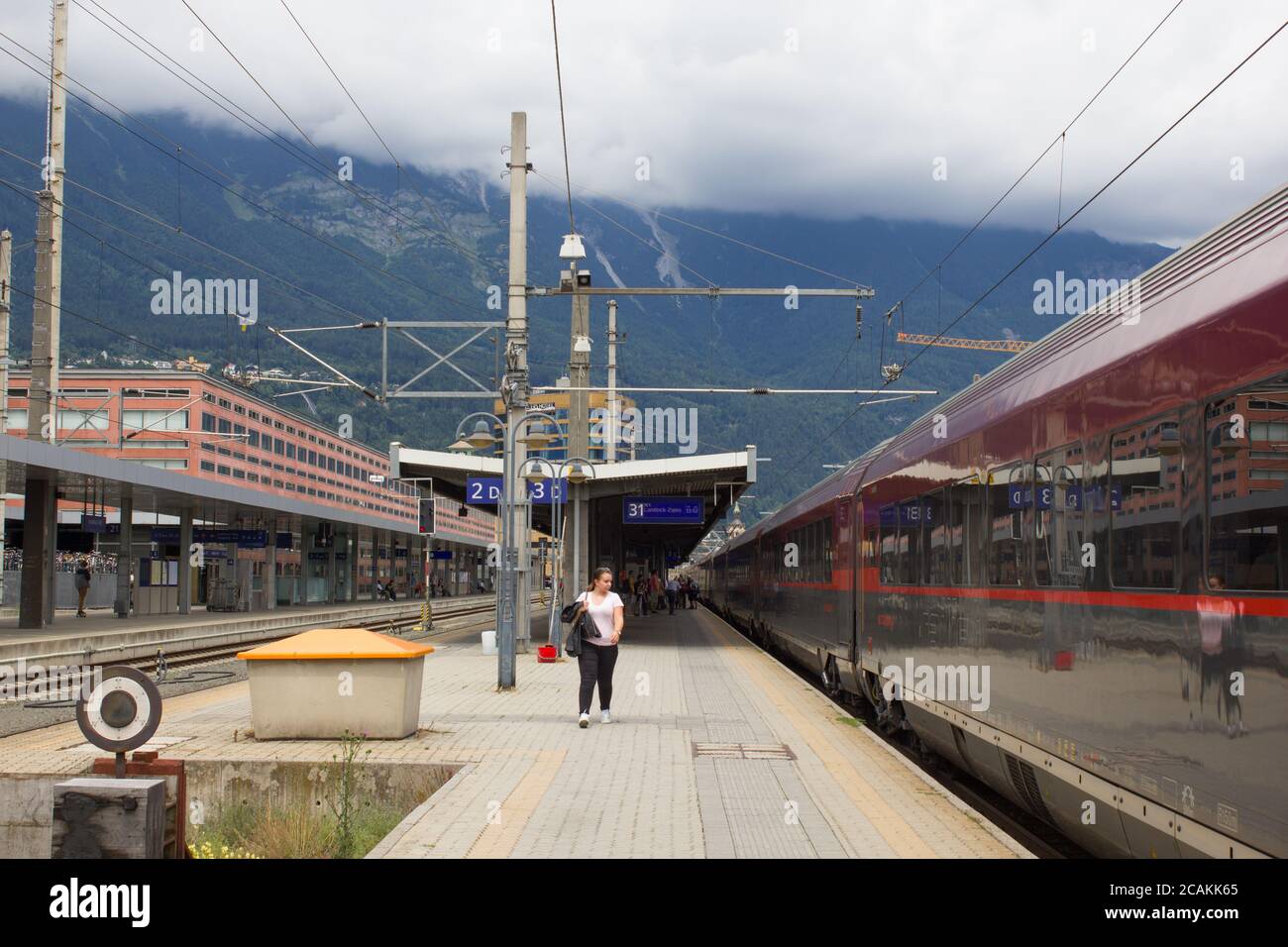 April 2020 - Innsbruck / Austria: An Austrian OBB railway train departing from the platform on the Innsbruck Main Railway Station on a cloudy day with Stock Photo