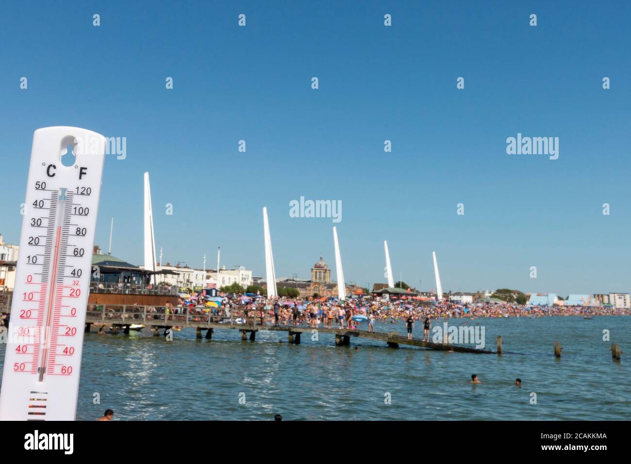 Busy beach on a hot day in Southend on Sea, Essex, UK during the COVID-19 Coronavirus pandemic. Thermometer reading 32 Celsius. People Stock Photo