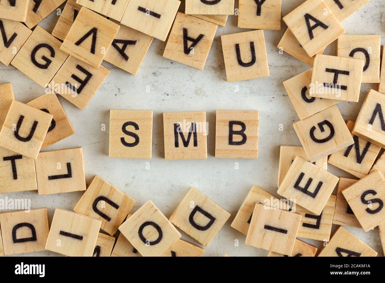 Top down view, pile of square wooden blocks with letters SMB (stands for Small to Medium Business ) on white board. Stock Photo