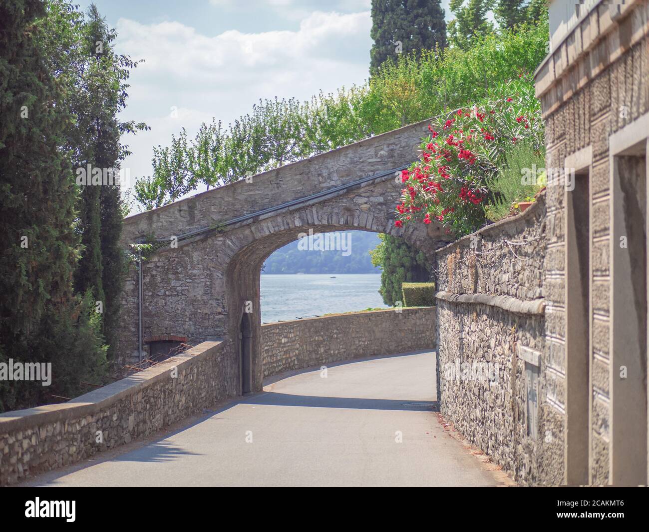 scenic road along the Lake Como through a stone arch Stock Photo