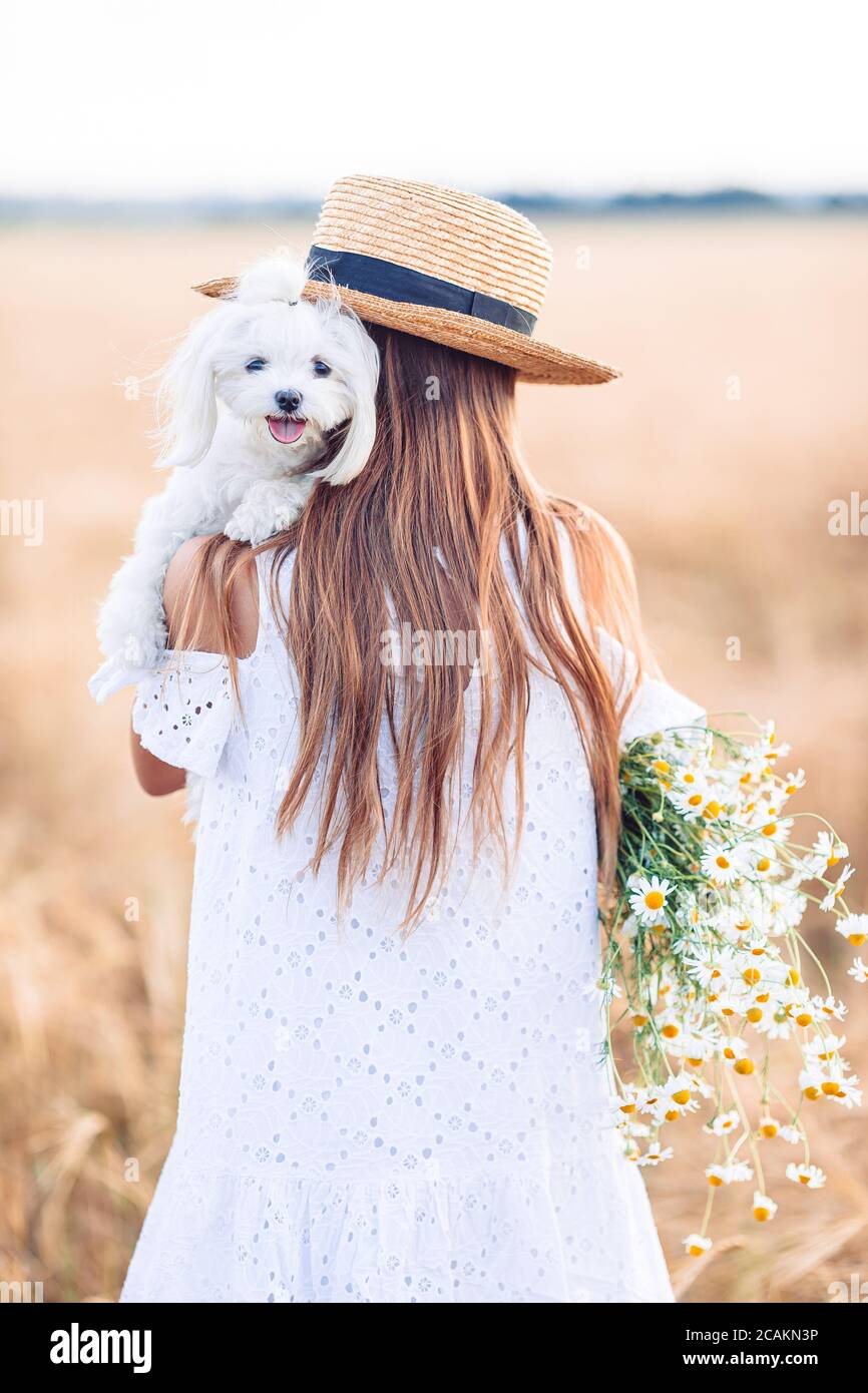 Happy child in wheat field. Beautiful girl in white dress in a straw ...