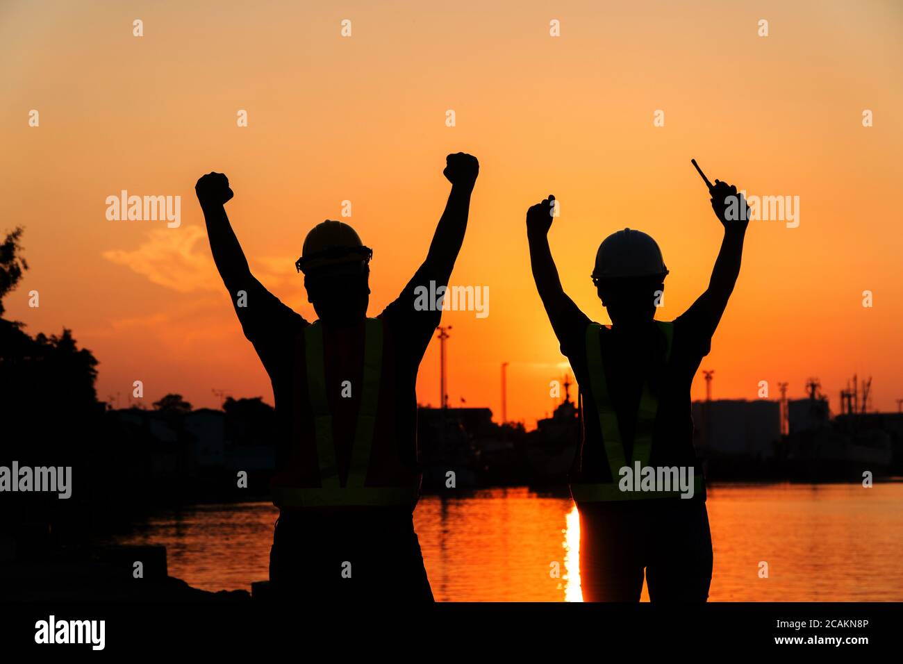 Silhouettes of worker and engineer Raising the hand up and standing on ...