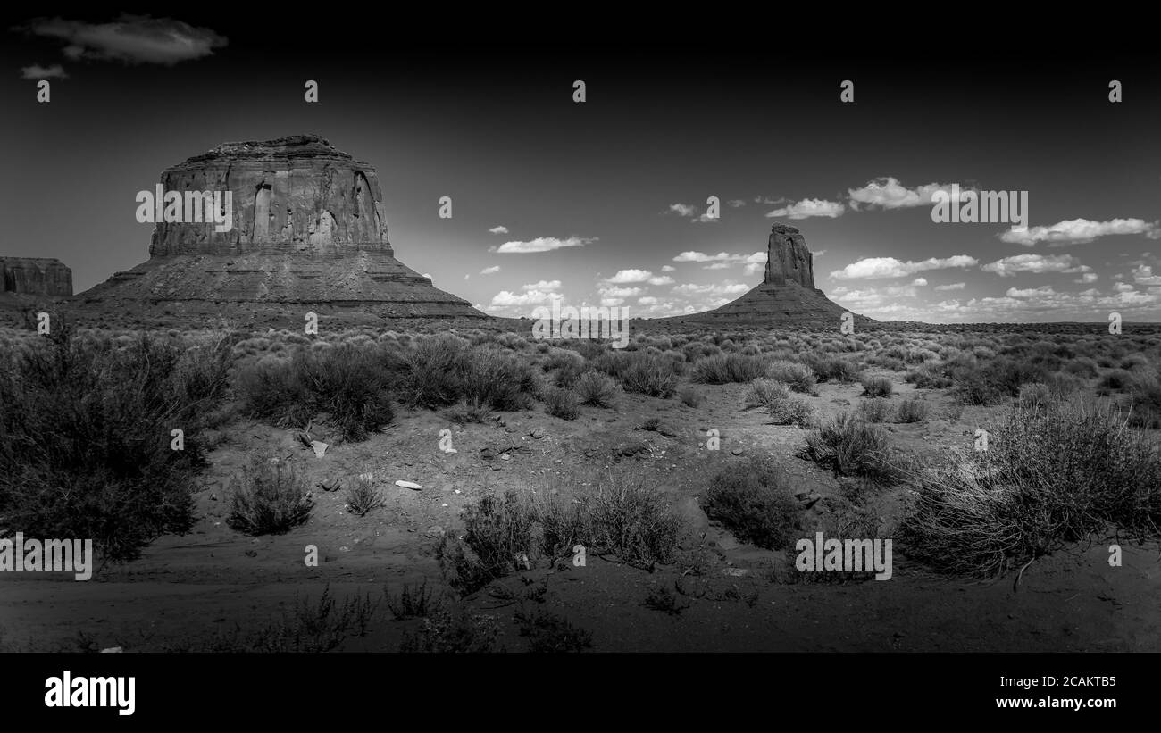 Black and White Photo of the sandstone formations of Merrick Butte and East Mitten Butte in the desert landscape of Monument Valley Navajo Tribal Park Stock Photo
