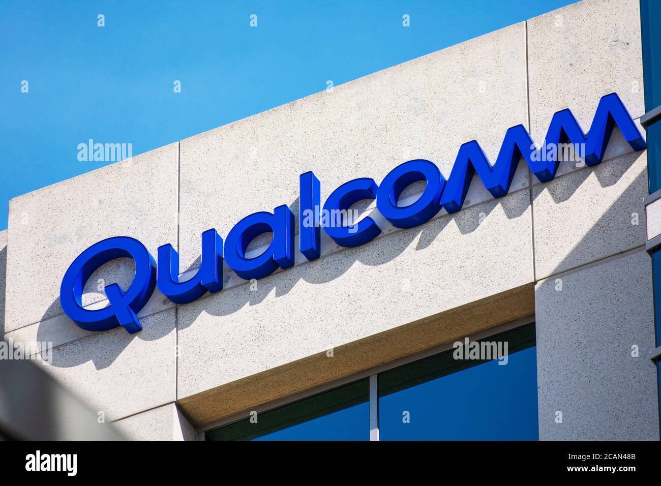 Close up. Qualcomm logo atop company office. Qualcomm Incorporated is