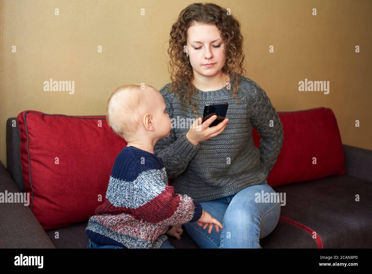 Mother Is Indifferent To Her Little Son Mom Looks At The Smartphone