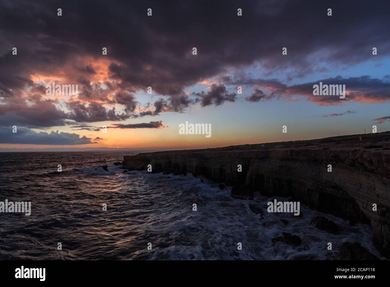 Sea Caves - Mediterranean Sea landscape near Ayia Napa, Cyprus during a stormy cloudy sunset Stock Photo