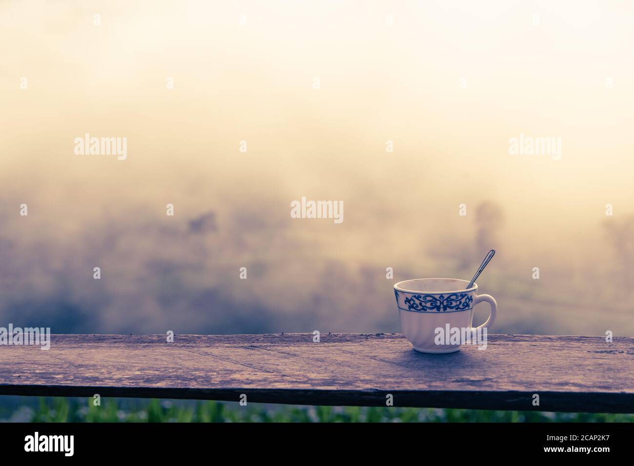 hot coffee on wood table winter over mountains landscape with sunlight morning nature background Stock Photo