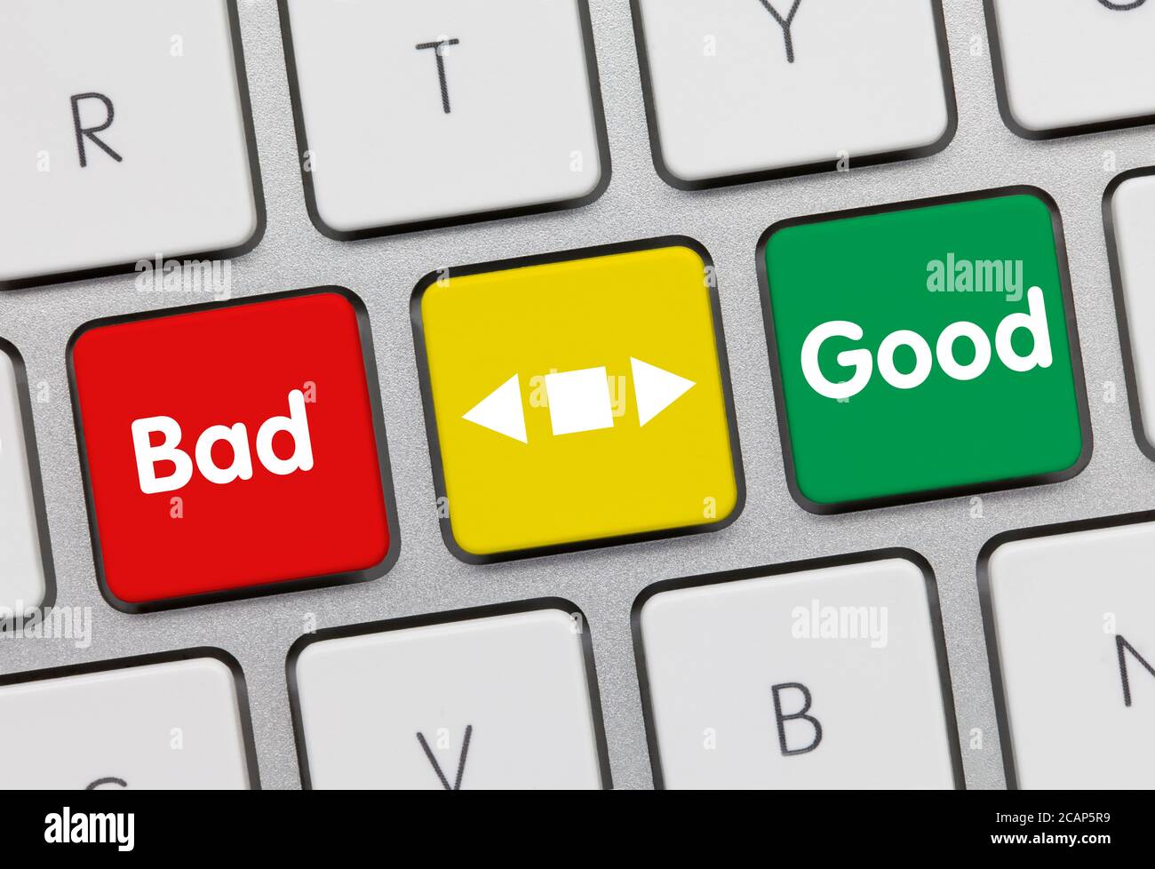 Bad or Good Written on Red-Yellow-Green Key of Metallic Keyboard. Finger pressing key. Stock Photo