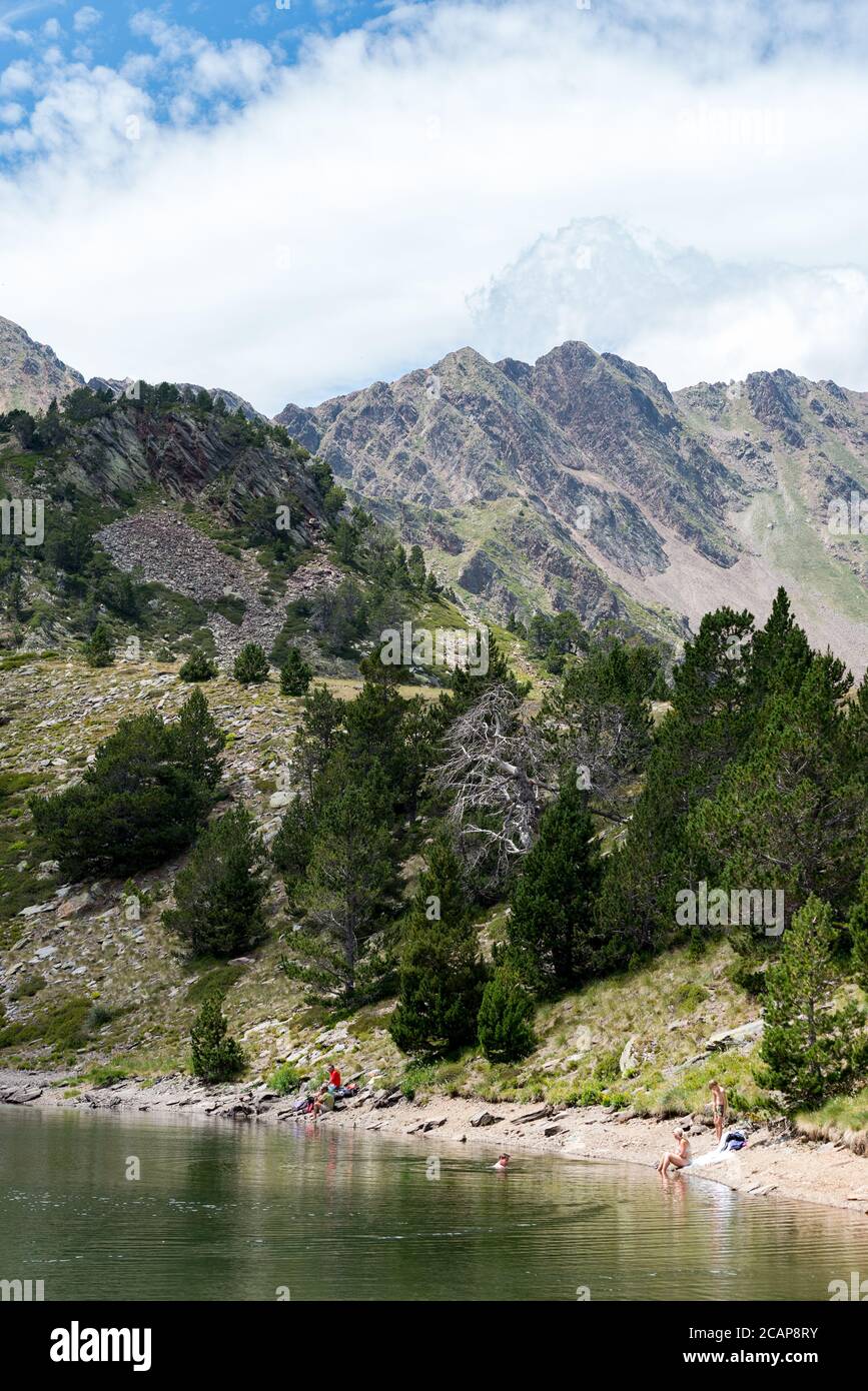 Coma Pedrosa, Andorra : 02 August 2020 :  Group of tourists resting at Lago de les Truites in Andorra Pyrenees in summer 2020. Stock Photo