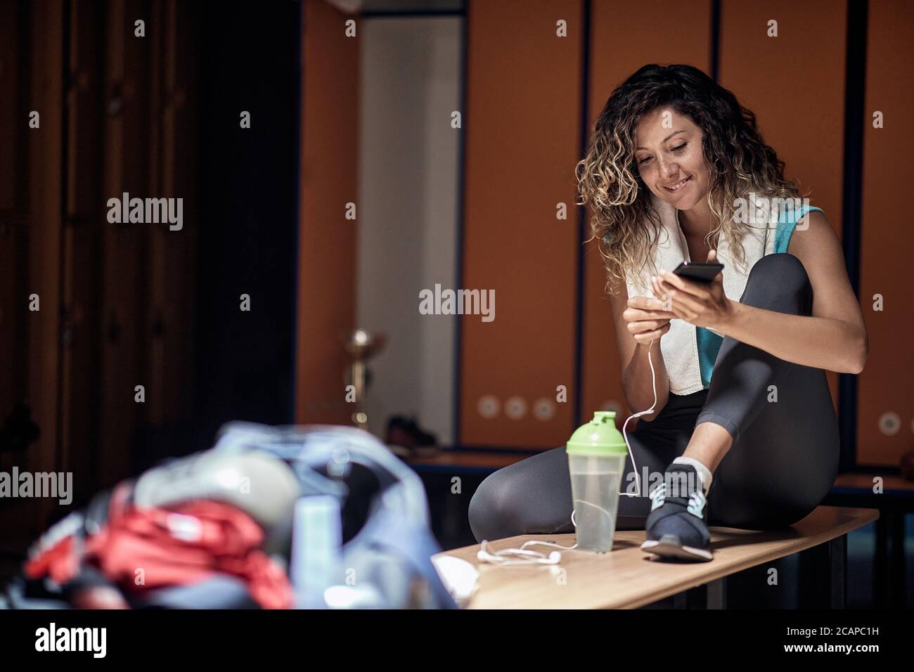 A young girl enjoying the music in a locker room after the fitness Stock Photo