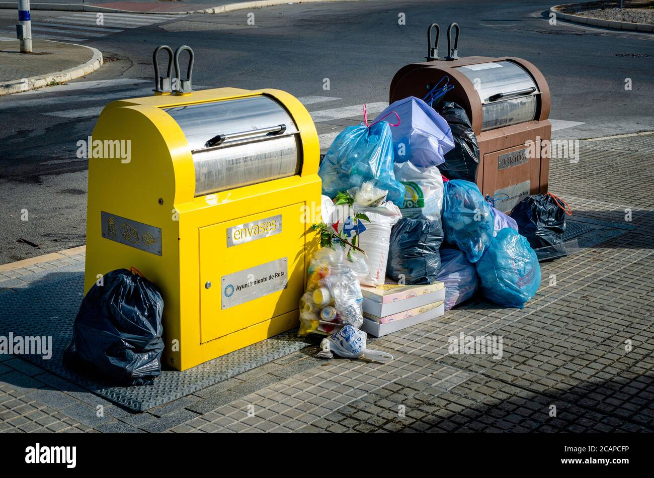 Full garbage and recycling bins with rubbish bags on the floor Stock