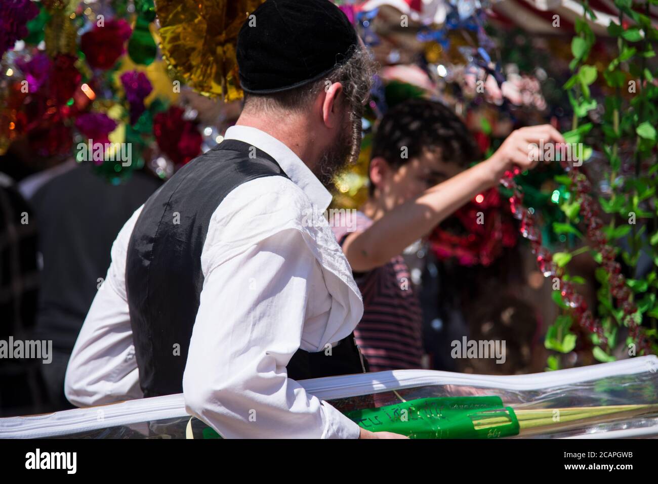 Jewish man wearing kippah. Sukkot's four species festival. Palm branch. Sukkah decorations Stock Photo