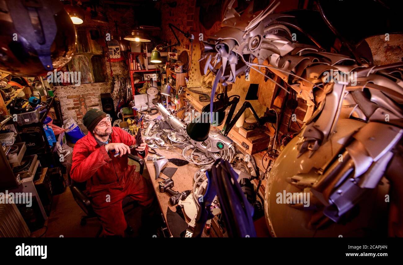 Artist Ptolemy Elrington at his Portslade studio in East Sussex UK where he create sculptures made from car hub caps and other reclaimed car parts. Stock Photo