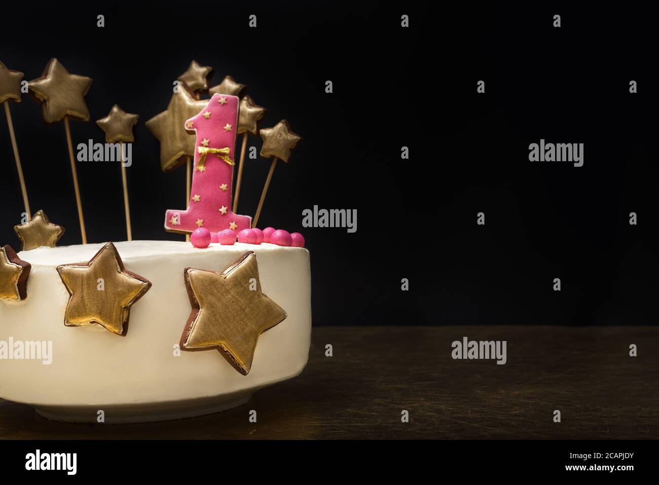 Birthday cake decorated with pink number 1 and gold stars of ...