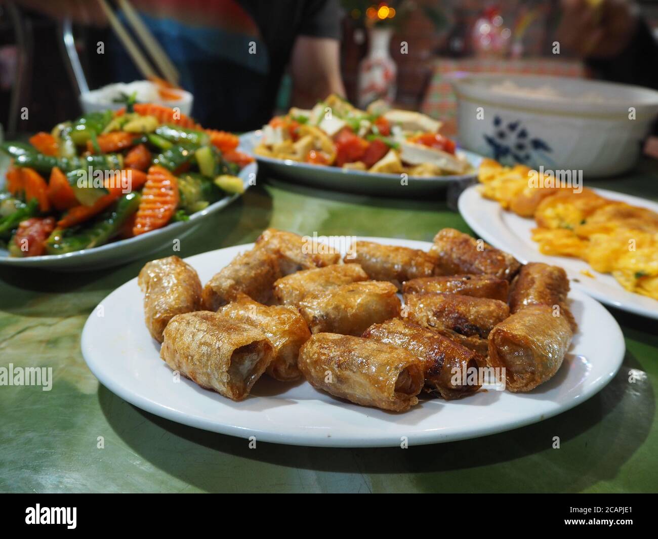 Fried Spring Rolls and Stir Fry Vegetables with Omelette and Rice - Traditional Home Cooked Vietnamese Meal Spread, Vegan Food in Asia Stock Photo