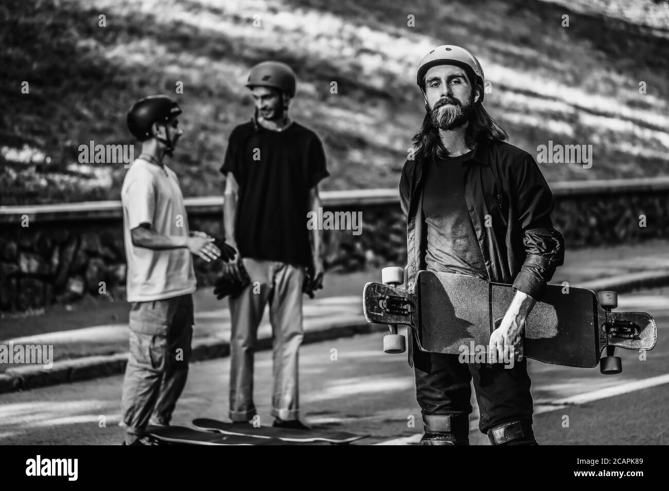 A group of guys ride longboards. Black and white portrait of a