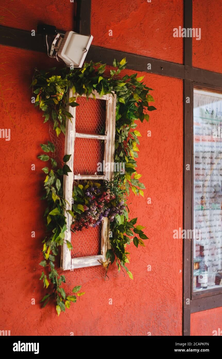 Side view of a shop display with red walls shaped as a lovely red colonial house in Vila Germânica, Blumenau - Brazil during the afternoon. Stock Photo