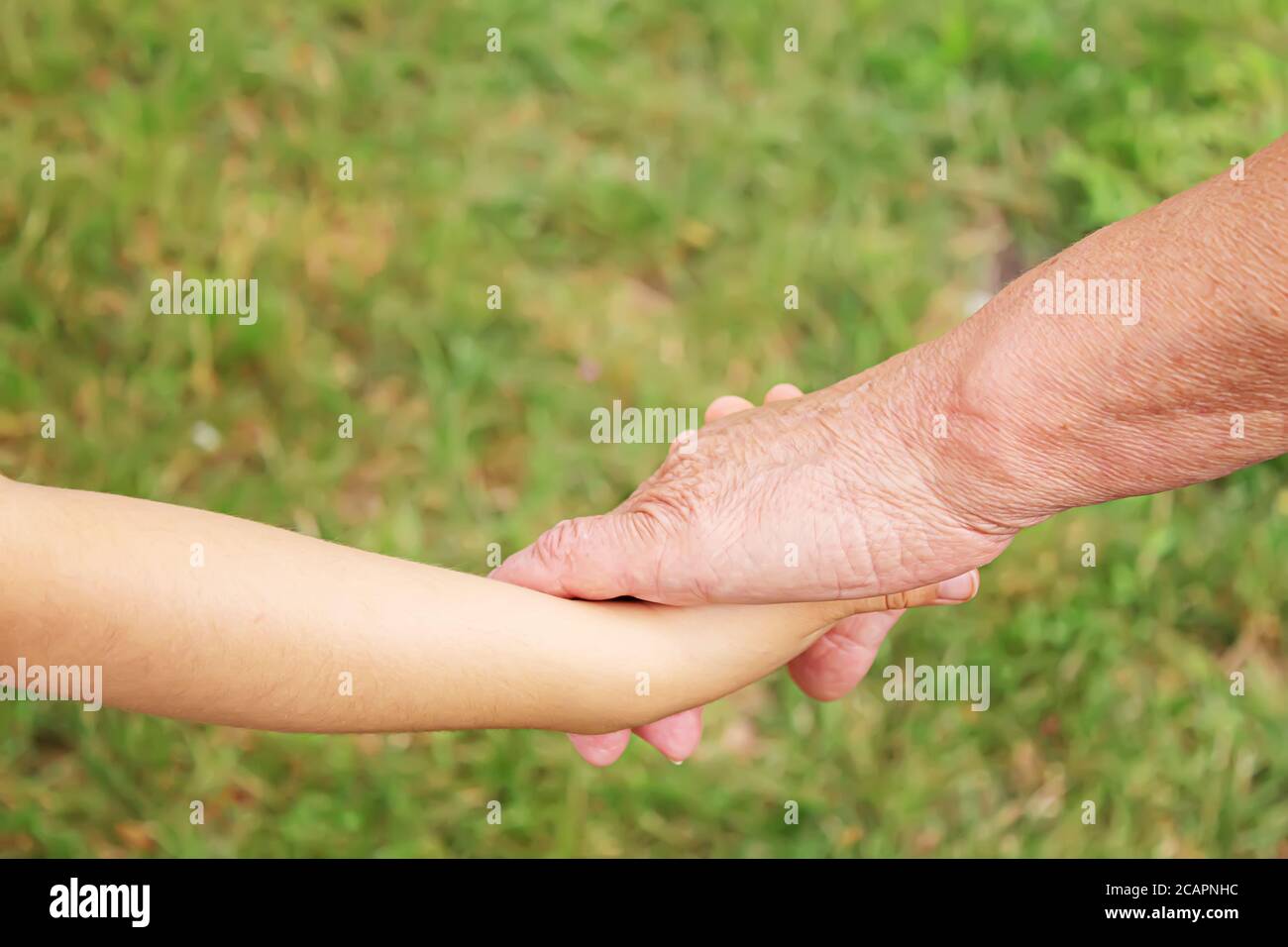 old man holding child's hands. selective focus Stock Photo