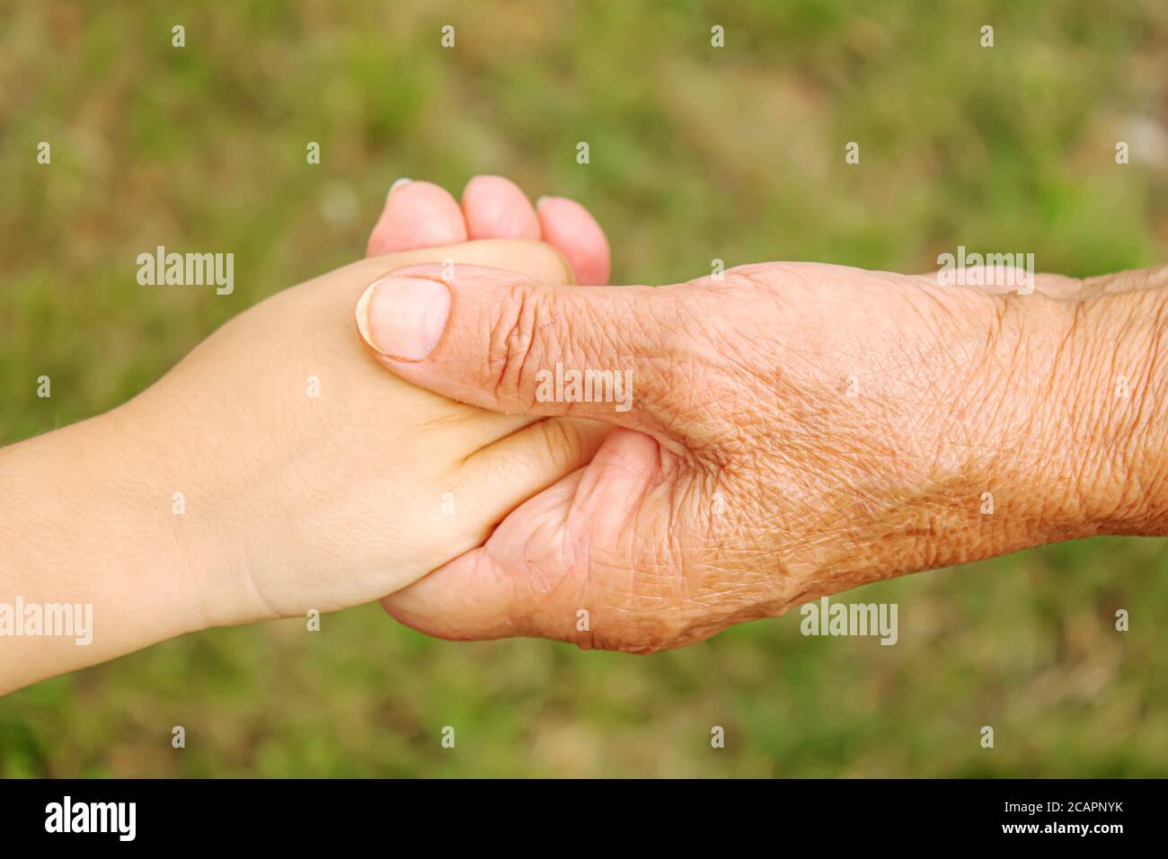 old man holding child's hands. selective focus Stock Photo