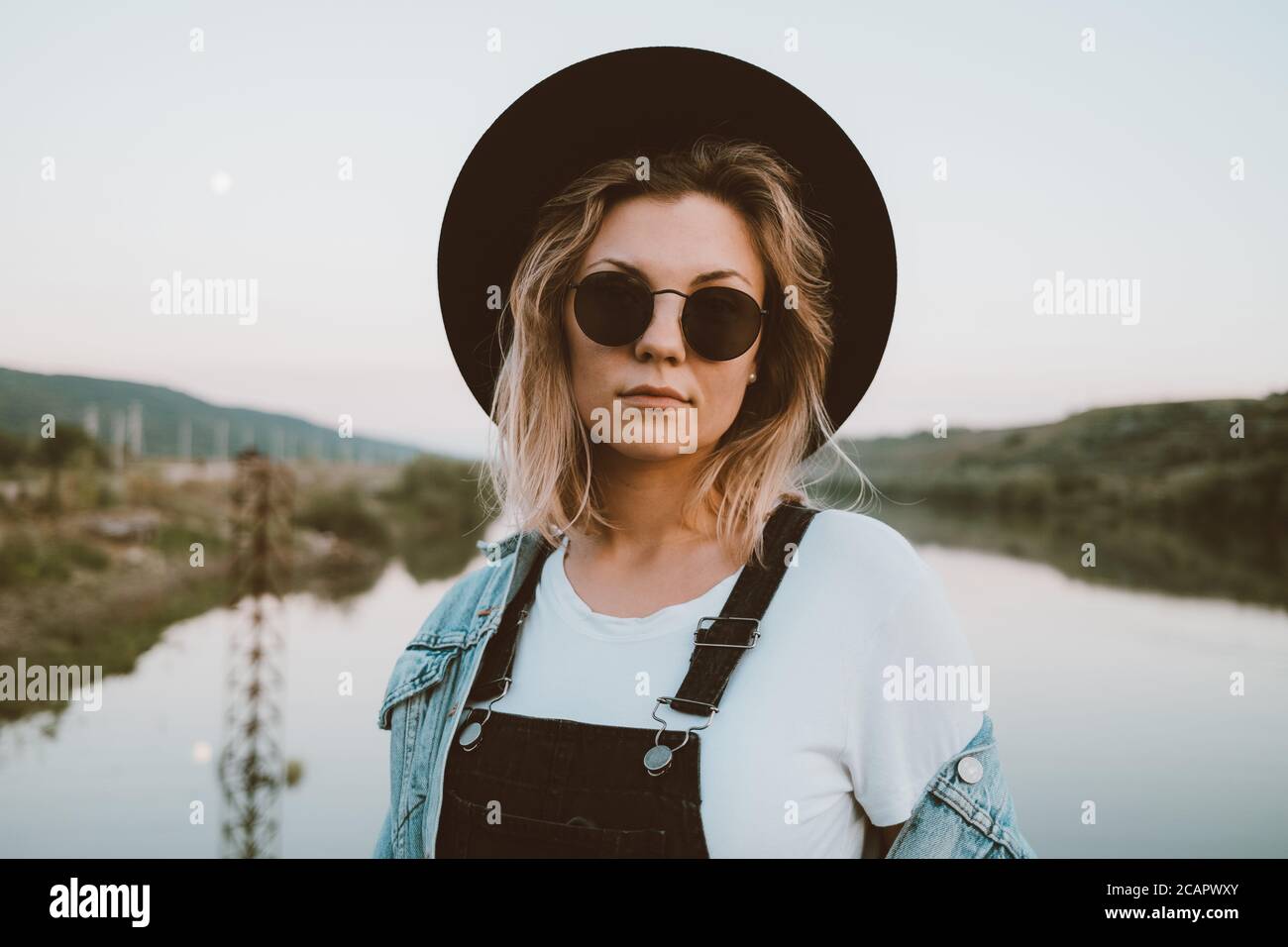 Young trendy hipster woman in black hat and dungaree Stock  display picture 1