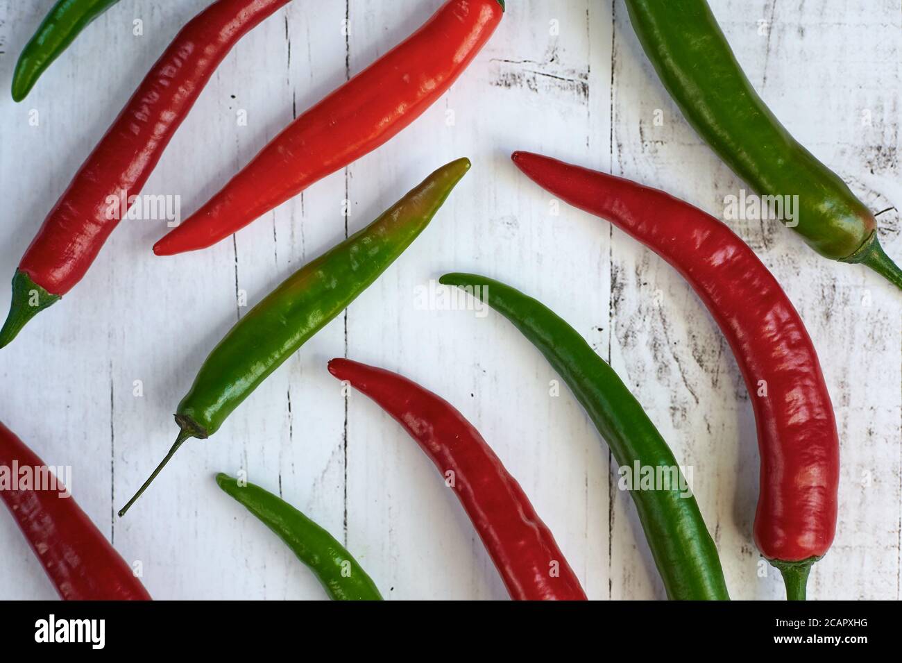 spicy green and red chilli on a light background from above close up ...